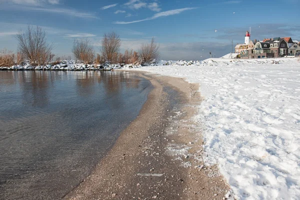 Dutch beach covered with snow and view at lighthouse Urk — Stock Photo, Image