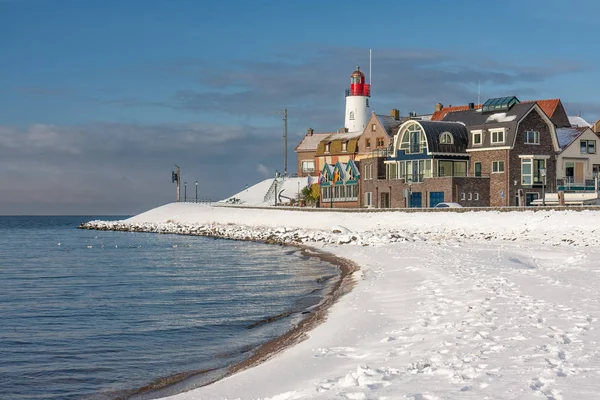 Nizozemské pláže pokryté sněhem a pohled na lighthouse Urk — Stock fotografie