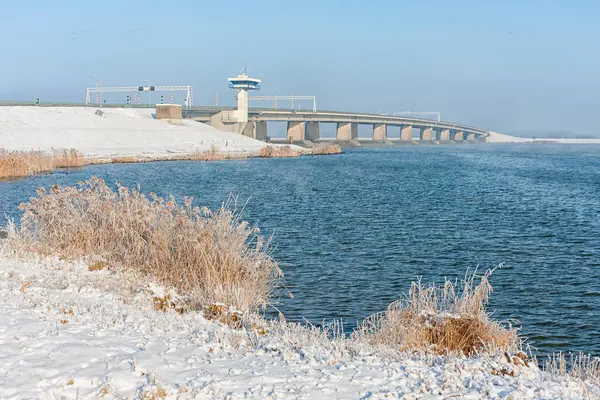 Niederländische Winterlandschaft mit Schnee und großer Betonbrücke — Stockfoto