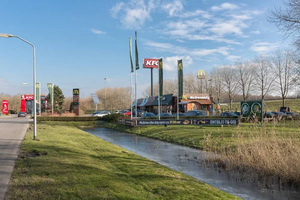 Parkeerplaats in de buurt van Nederlandse snelweg met Fast-food restaurants — Stockfoto