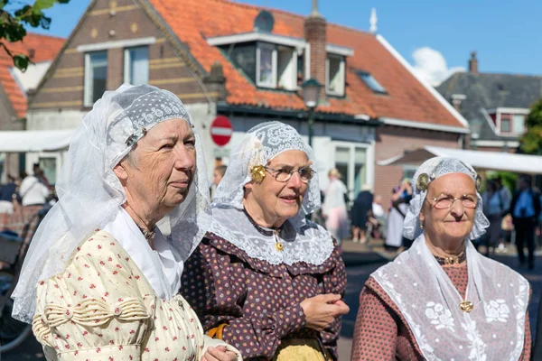 Nederlandse vrouwen met traditionele kleding en hoofddeksels op lokale beurs — Stockfoto