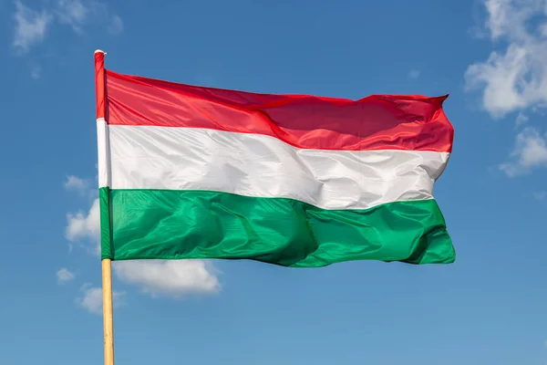 Венгерский национальный флаг, размахивающий ветром на фоне голубого неба — стоковое фото