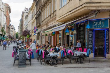 Budapeşte Vaci Caddesi 'ndeki restoranın önünde oturan insanlar.