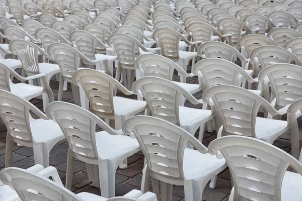 Chaises en plastique blanc dans la rangée stand attendant les visiteurs — Photo