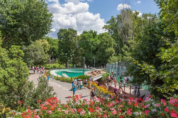 Budapest zoo with people at footpath surrounded with beautiful flowers — Stock Photo, Image