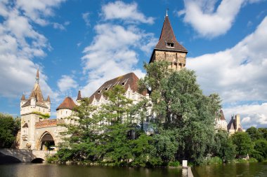 Budapeşte Vajdahunyad Kalesi göl kenarından ve gökyüzünden bulutlu görünüyor