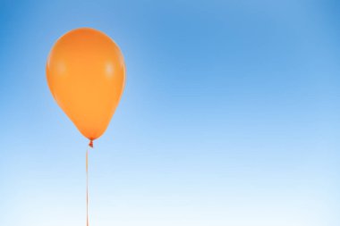 Doğum günü için turuncu balon ve mavi gökyüzünde izole edilmiş kutlamalar