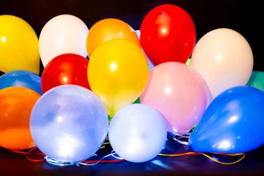 Koyu arkaplana karşı öncülük eden renkli balonlar