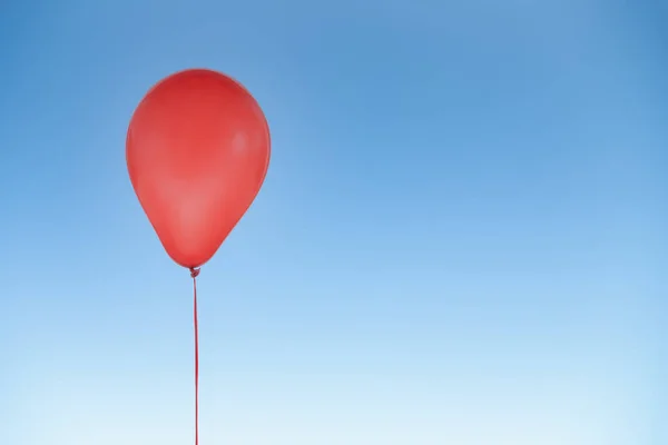 Doğum günü için kırmızı balon ve mavi gökyüzünde izole edilmiş kutlamalar — Stok fotoğraf