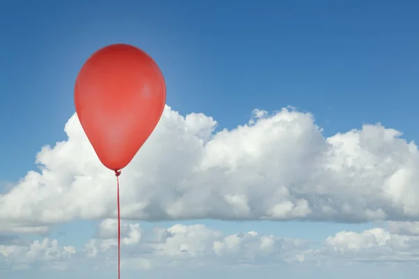 Rød ballong isolert på blå himmel med skyer – stockfoto