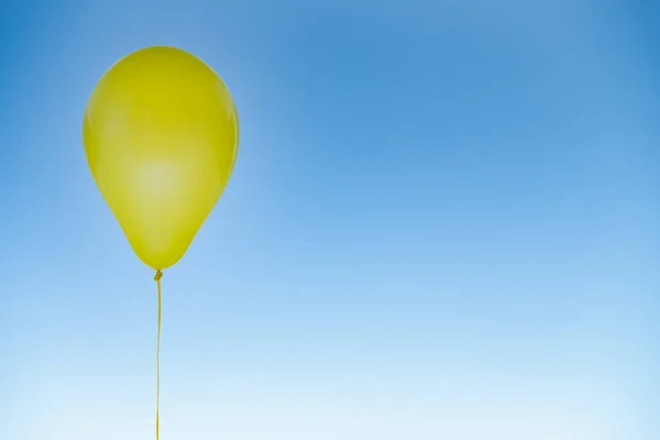 Yellow balloon for birthday and celebrations isolated at blue sky