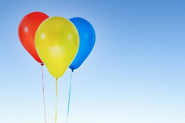 Doğum günü için renkli balonlar ve mavi gökyüzünde izole edilmiş kutlamalar. — Stok fotoğraf