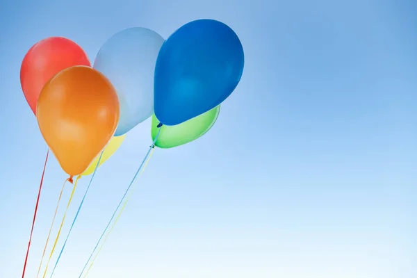 Doğum günü için renkli balonlar ve mavi gökyüzünde izole edilmiş kutlamalar. — Stok fotoğraf