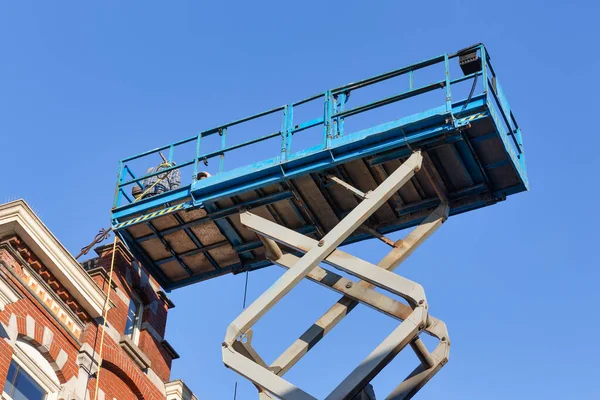 Work platform with builders repairing roof historic Dutch house