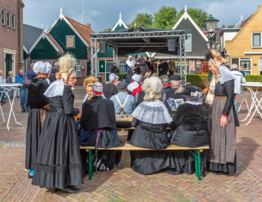 Hollanda yerel fuarında geleneksel giysi ve başlık takanlar