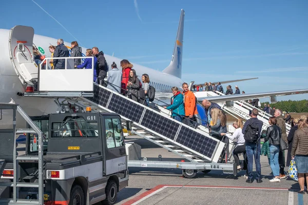 Resenärer som kommer in i ett flygplan redo för avgång vid Eindhovens flygplats — Stockfoto