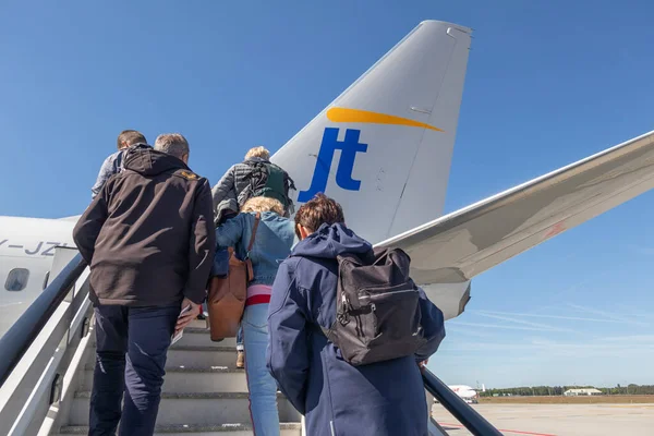 Reizigers stappen in een vliegtuig klaar voor vertrek op vliegveld Eindhoven — Stockfoto