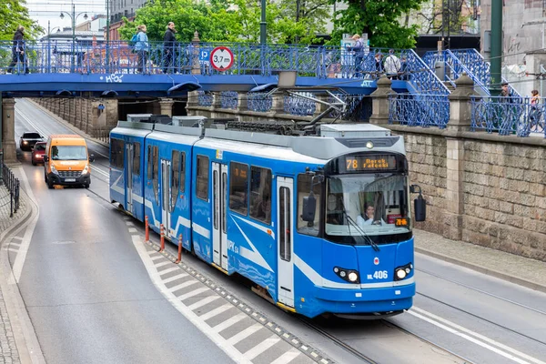 Straßenbahn in Krakau, während Menschen über Fußgängerbrücke die Straße überqueren — Stockfoto