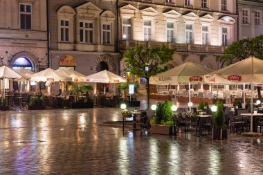 Akşam Krakow Meydanı 'nda boş teraslarla yağmur yağarken