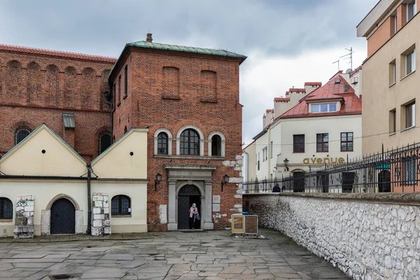 Samotna kobieta opuszczająca Starą Synagogę w dzielnicy żydowskiej Kraków, Polska — Zdjęcie stockowe
