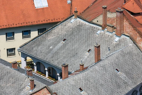 Historic building with slate roof and brick chimneys — Stock Photo, Image