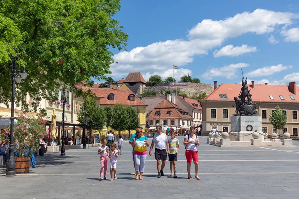 Familie wandelen op het centrale plein Eger met standbeeld Istvan Dobo — Stockfoto