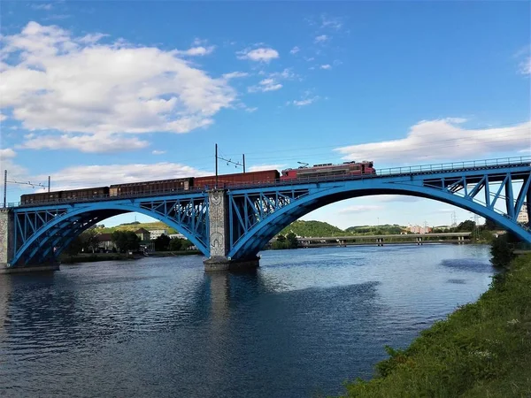 Niebieski most i pociąg nad rzeką Drava w Mariborze — Zdjęcie stockowe