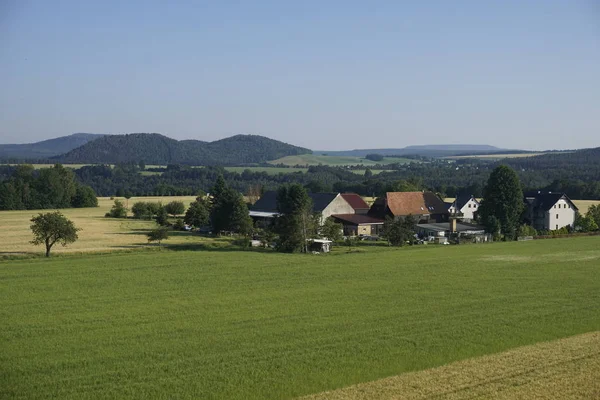 Vista sobre a aldeia de Rathmannsdorf com as colinas da Suíça saxã — Fotografia de Stock