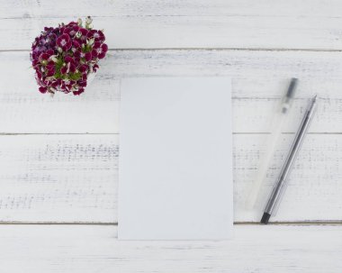 Boş beyaz kartı iki siyah kalem ve koyu kırmızı tatlı williams buket 