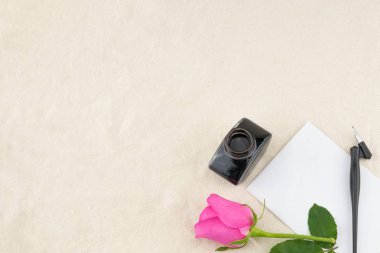 Boş beyaz kartı, eğik kalem ve mürekkep şişe pembe Gül beyaz muslin kumaş kopya alanı ile süslenmiş