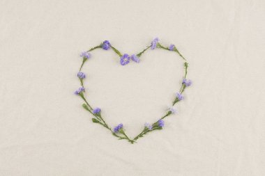 Mor kesici çiçek kopya alanı ile beyaz muslin kumaş üzerine yapılan kalp şekli çerçeve