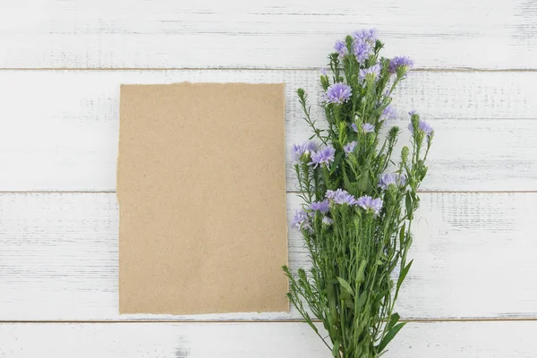 木製白地紫カッター花ブーケと茶色ダミーカード — ストック写真