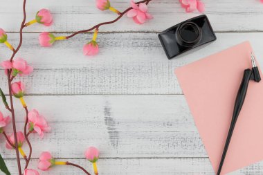 Boş pembe kart, eğik kalem ve mürekkep şişe sahte Pembe çiçek dallarda kopya alanı ile beyaz tahta arka plan ile dekore edilmiş