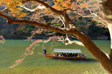 Sonbahar, Arashiyama, Kyoto, Japonya Hozugawa Nehri boyunca turist tekne sandal kayıkçı