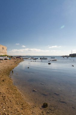 Bir Akdeniz kenti kıyısına yakın bir sığ ve sakin denizde yüzen tekne