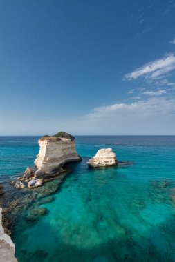 Arka plan olarak mavi bir gökyüzü ile sakin bir mavi denizde deniz yığınları