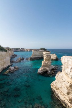 Arka plan olarak mavi bir gökyüzü ile sakin bir mavi denizde deniz yığınları