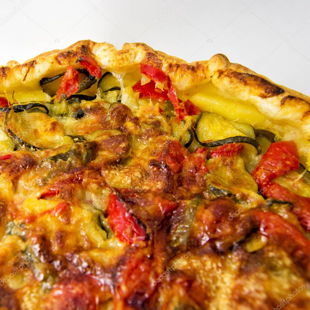 vegetables salad pie. quiche with zucchini, peppers, potatoes and puff pastry. for vegerarian cousine concept