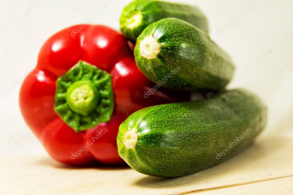 soft focus of fresh red pepper and green zucchini on a white background
