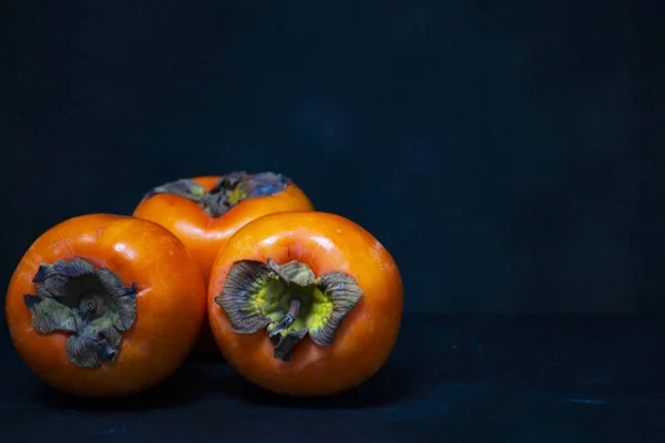 Tres kaki de vainilla de caqui o kaki de manzana Imágenes de stock libres de derechos