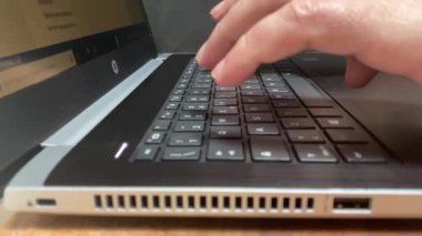 Adam, COVID-19 salgını sırasında Coronavirus 'un yayılmasını önlemek için evden uzaktan çalışan bir dizüstü bilgisayarı daktilo ediyor.