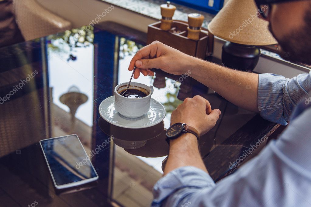 Hombre barbudo sentado con taza de café de la mañana y
