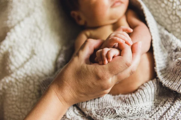 Новорожденный младенец держит материнский палец — стоковое фото