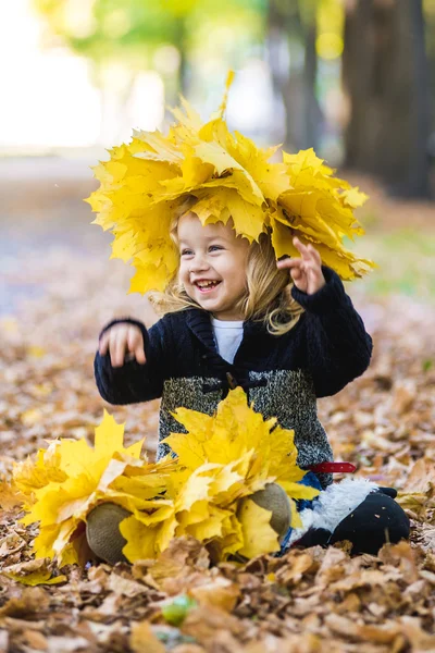 Beautiful little girl in a wreath of maple leaves — Stock Photo, Image