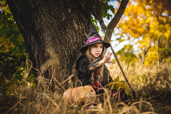 Joyeux Halloween. Petite sorcière mignonne avec une citrouille dans les mains. — Photo