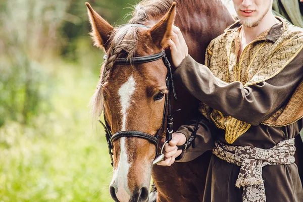Perto de uma cabeça de cavalo com detalhes no olho e na mão do cavaleiro . — Fotografia de Stock