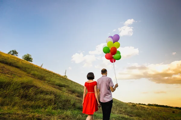 Coppia felice di uomo e donna innamorati, con palloncini multicolori — Foto Stock