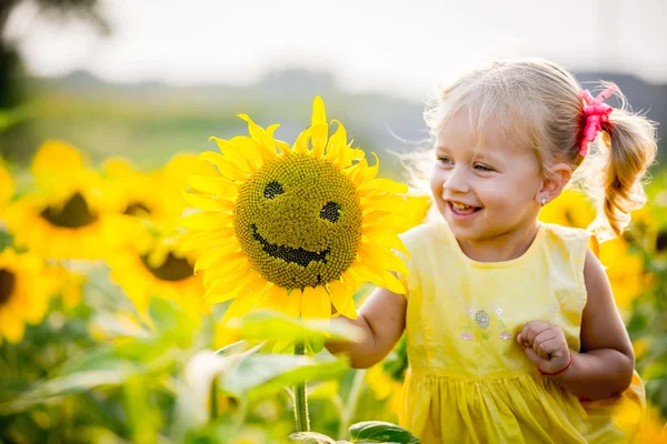 Mooie meisje in zonnebloemen — Stockfoto