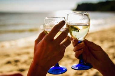 Genç çift sahilde şarap içme.