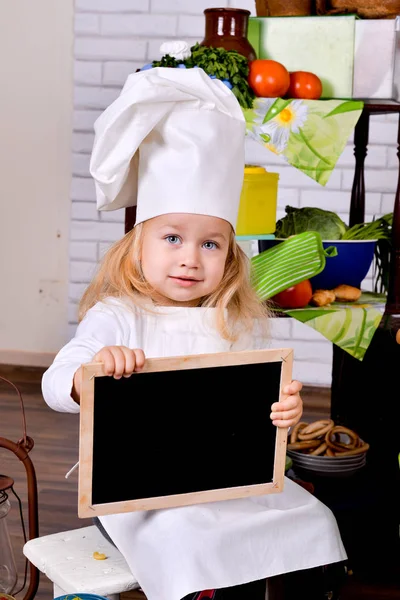 Szef kuchni piękne dziecko trzyma tablicę ogłoszeń — Zdjęcie stockowe